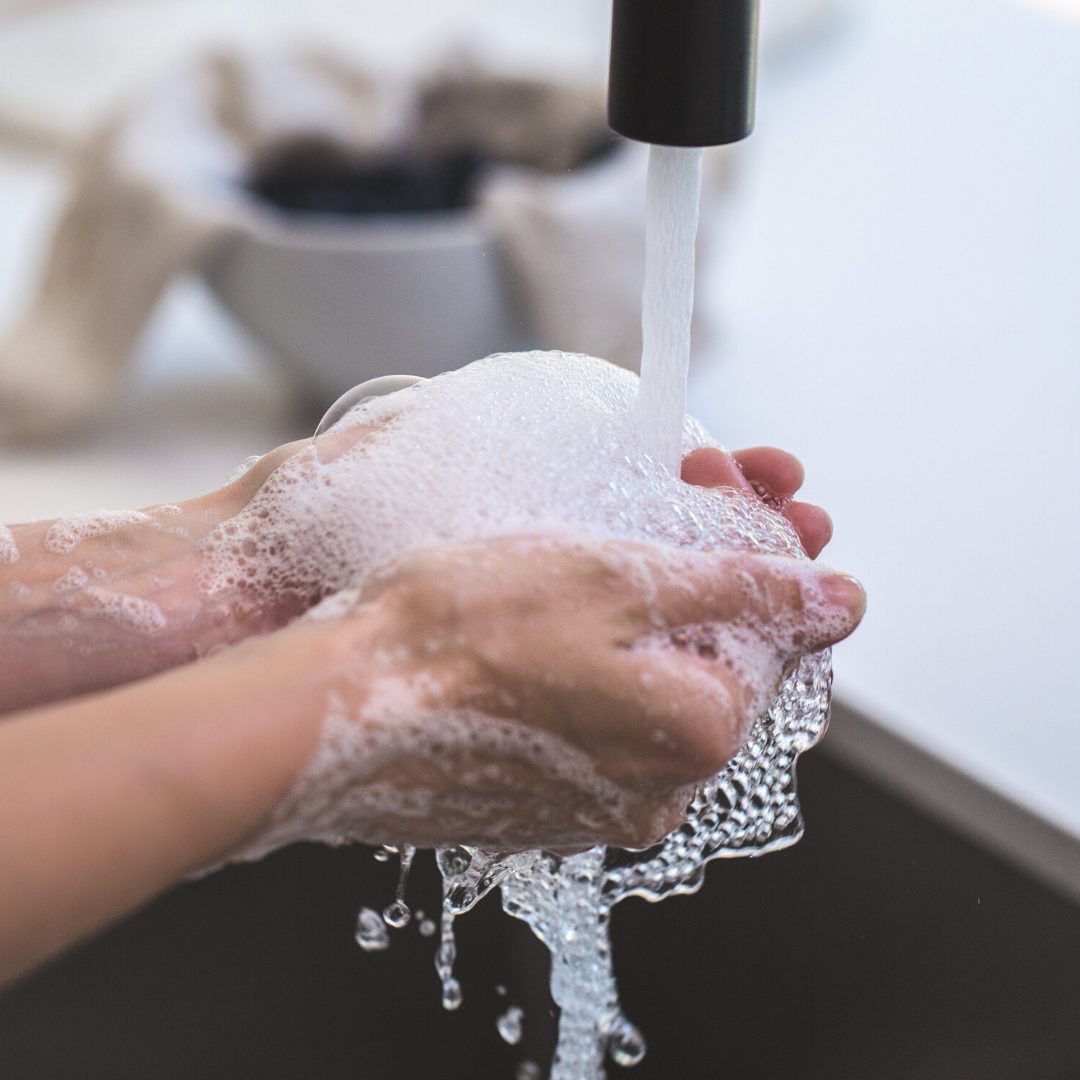 washing hands with soap under kitchen tap